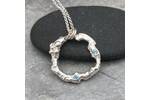 Organic silver circle pendant with two blue Topaz stones.