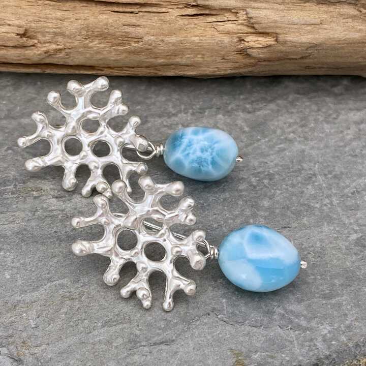 This is a picture of a pair of silver coral shaped earrings with Larimar gemstones