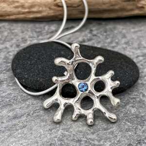 This is a picture of an organic silver pendant with an Aquamarine gemstone