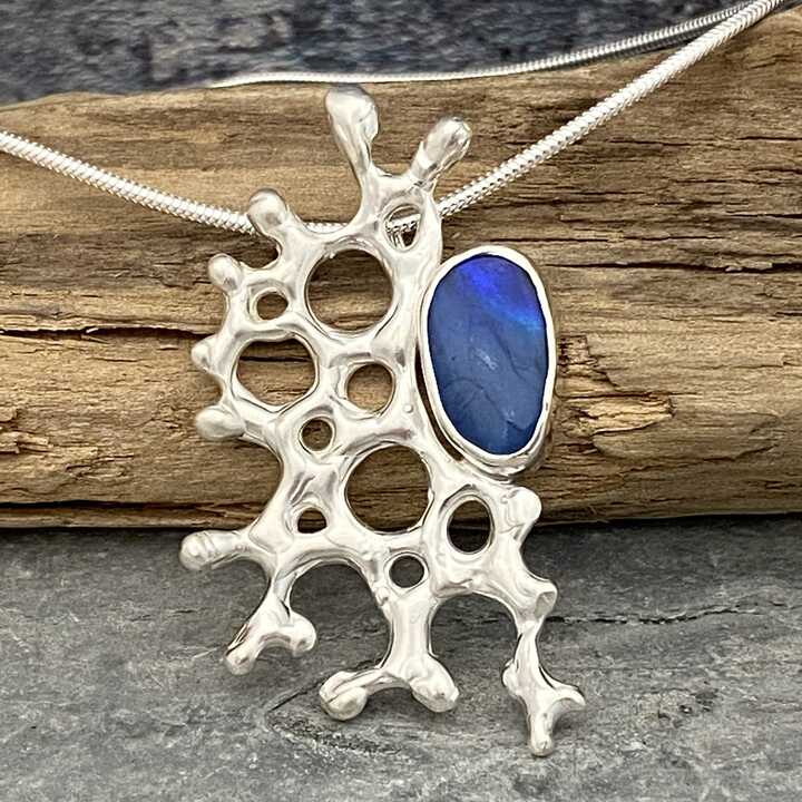 This is a picture of a silver coral inspired pendant with Opal stone