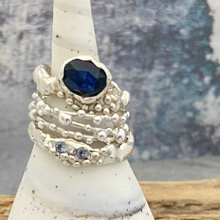 This is a picture of a t’s tack of three silver rings with blue gemstones 